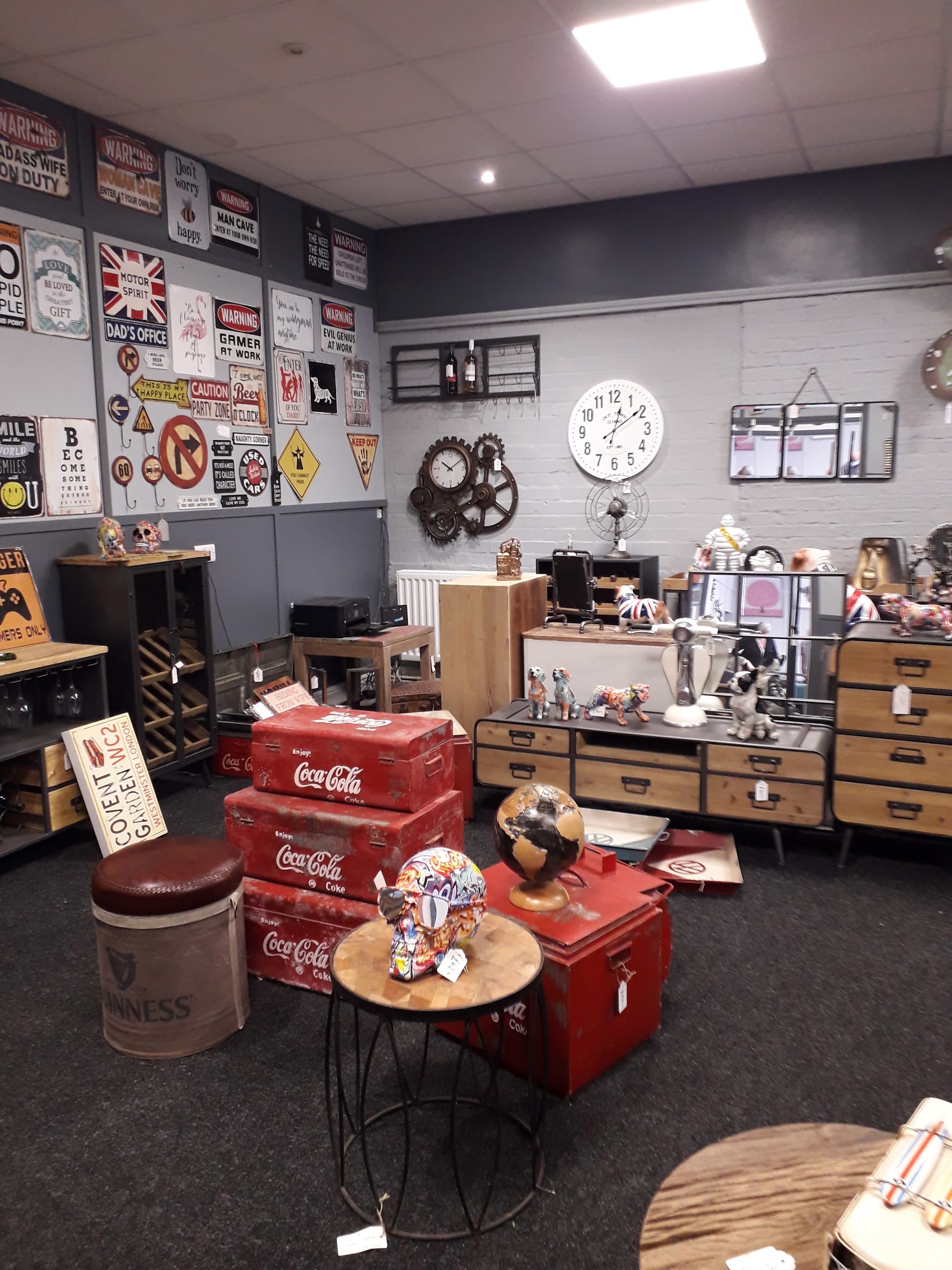 A corner of the showroom with vintage metal signs, wall clocks, Coca-Cola trunks and sideboards
