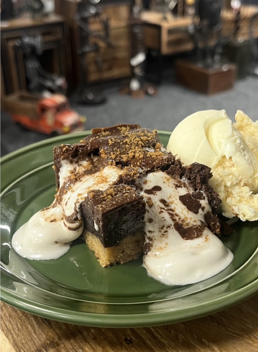 A chocolate topped bake with scoops of vanilla ice cream