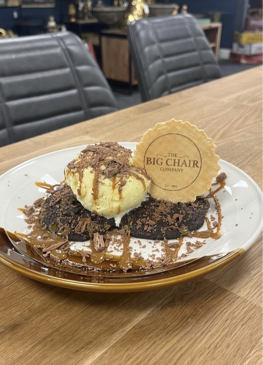 A brownie with scoops of ice cream, caramel and a Big Chair Company wafer