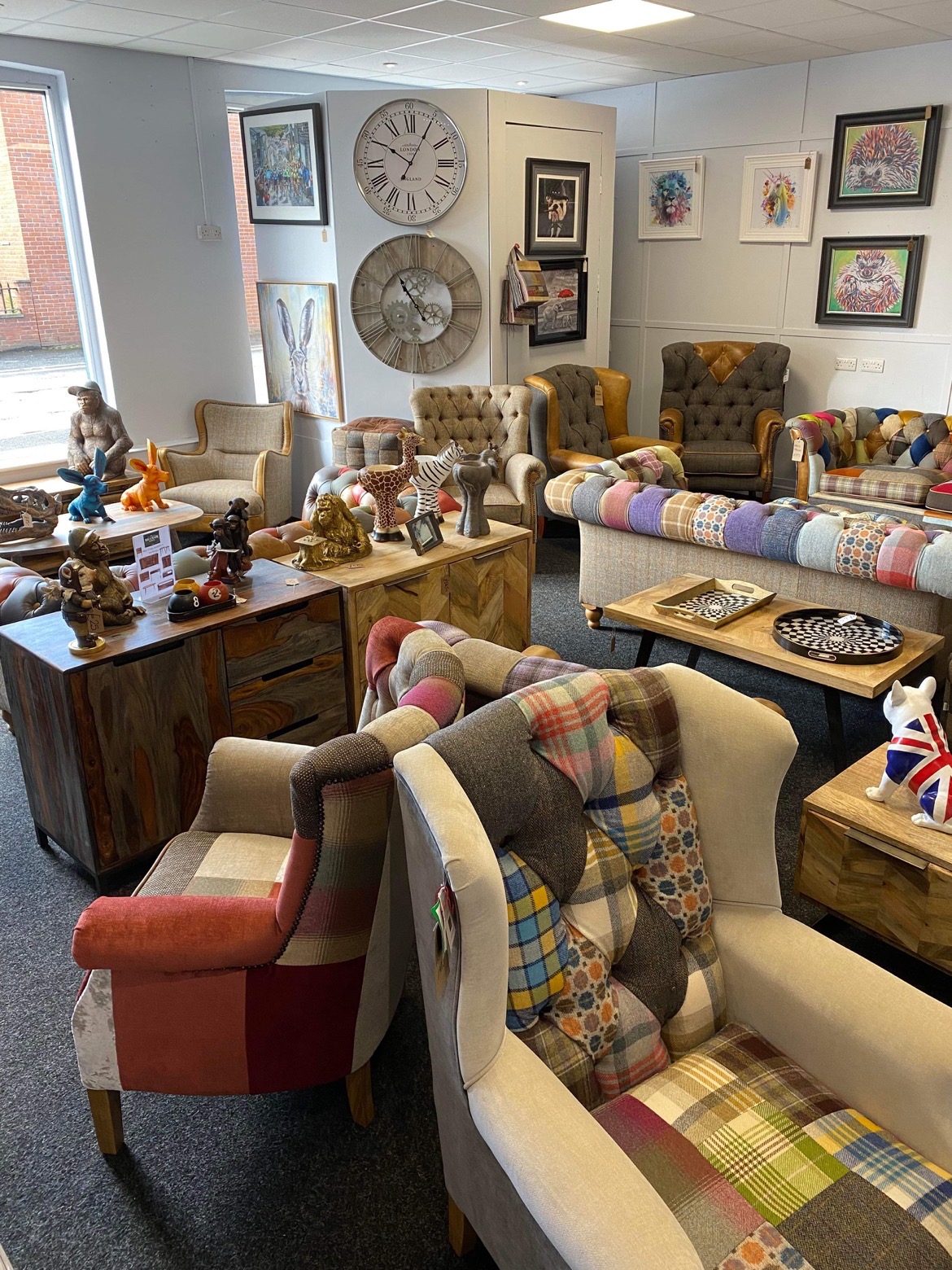 Patchwork armchairs, sofas, sideboards and wall clocks arranged in the showroom